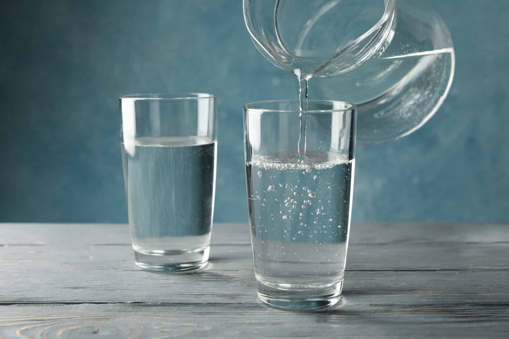 Verser de l'eau douce purifiée de la cruche en verre