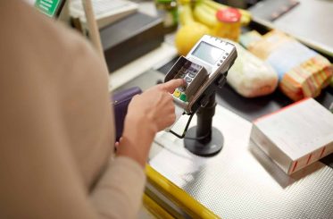 Femme saisissant le code PIN à la caisse enregistreuse du magasin